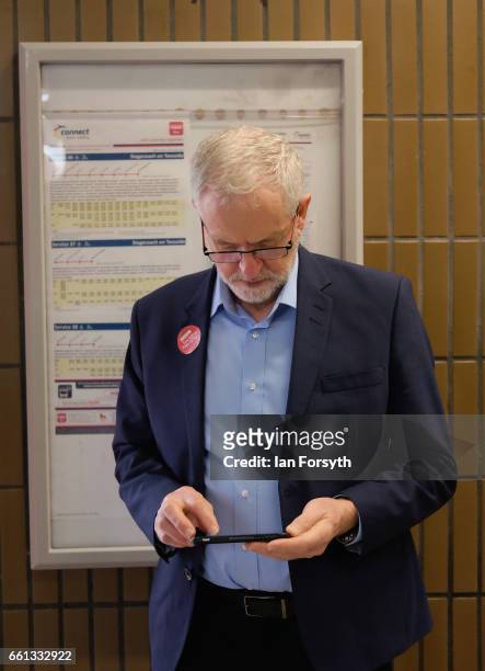 Labour leader Jeremy Corbyn checks his phone as he waits to take a ride on the number 36 bus from Middlesbrough to Stockton on Tees on March 31, 2017...