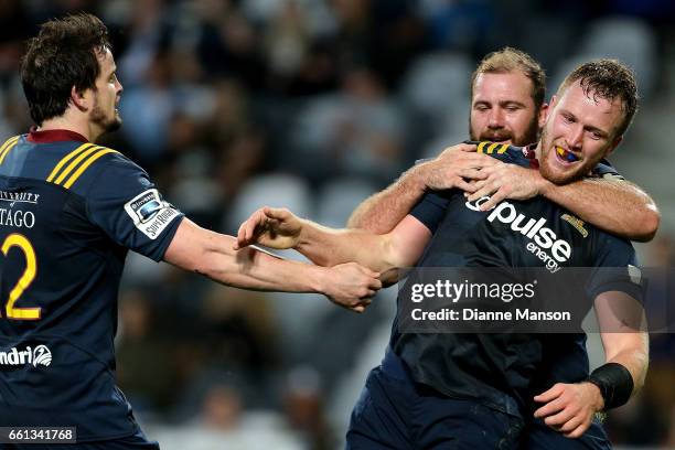 Gareth Evans celebrates his try with team mates Richard Buckman and Greg Pleasants-Tate of the Highlanders celebrates his try during the round six...