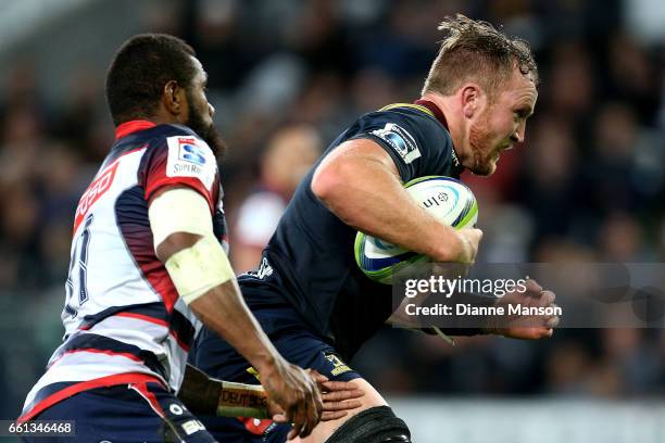 Gareth Evans of the Highlanders dives over to score a try while in the tackle of Marika Koroibete of the Rebels during the round six Super Rugby...