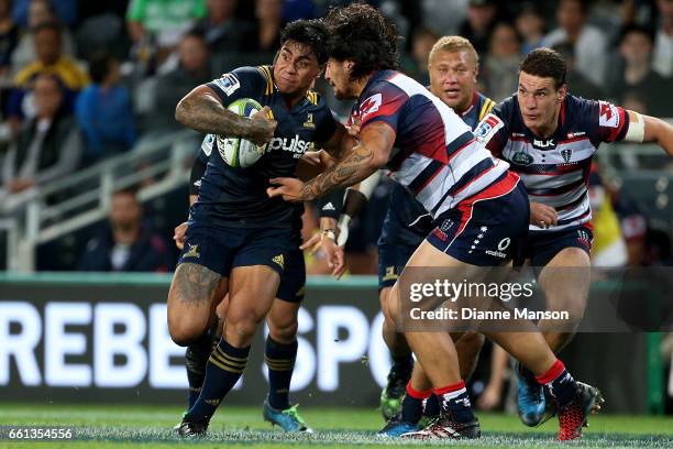 Malakai Fekitoa of the Highlanders tries to break the defence of the Rebels during the round six Super Rugby match between the Highlanders and the...