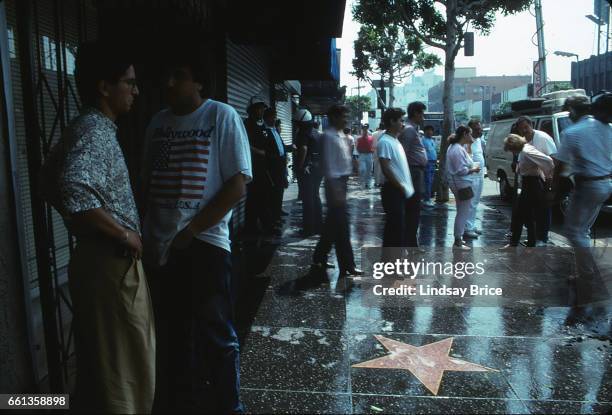 May 1 - Rodney King Riot. View of police officers standing in riot helmets and merchants inspecting damage to their businesses along the Walk of Fame...