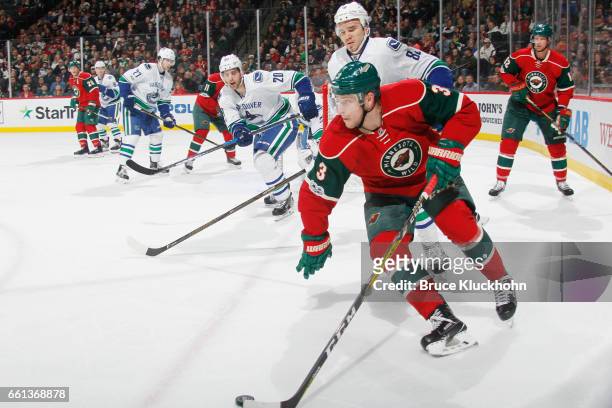 Charlie Coyle of the Minnesota Wild skates with the puck while Nikita Tryamkin of the Vancouver Canucks defends during the game on March 25, 2017 at...