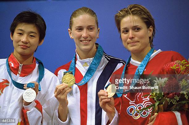 Laura Wilkinson of the United States, center, shows off her Gold Medal as Li Na of China, left, displays her Silver and Anne Montminy of Canada holds...