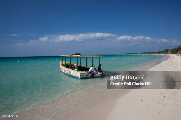 Glass bottomed boat moored at Seven mile beach in the translucent waters, Negril, Jamaica. .