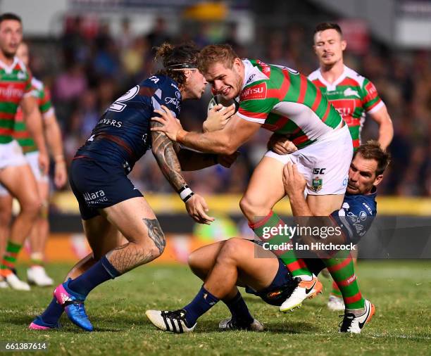 Tom Burgess of the Rabbitohs is tackled by Scott Bolton and Ethan Lowe of the Cowboys during the round five NRL match between the North Queensland...