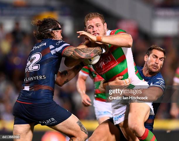 Tom Burgess of the Rabbitohs is tackled by Scott Bolton and Ethan Lowe of the Cowboys during the round five NRL match between the North Queensland...