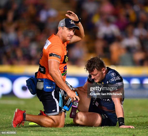 Coen Hess of the Cowboys receives treatment after being injured during the round five NRL match between the North Queensland Cowboys and the South...