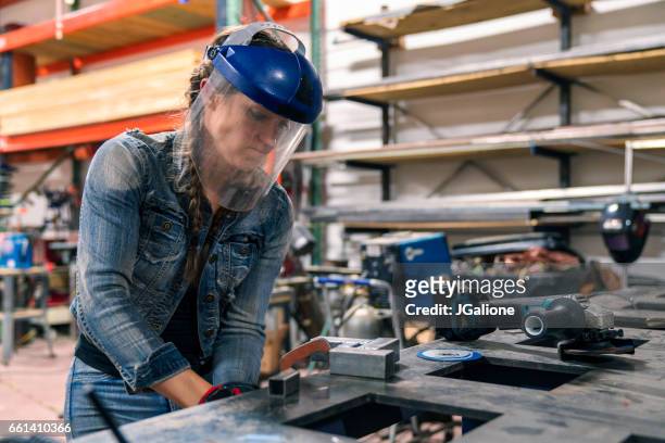 woman tightening a vice to secure metal in place - helmet visor stock pictures, royalty-free photos & images