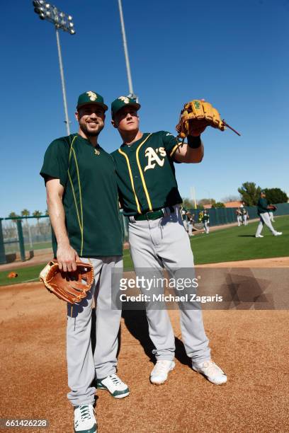 Matt Chapman and Trevor Plouffe of the Oakland Athletics stand on the field during a workout at Fitch Park on February 20, 2017 in Mesa, Arizona.