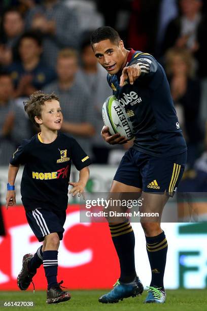 Aaron Smith runs out on field for his 100th match for the Highlanders during the round six Super Rugby match between the Highlanders and the Rebels...