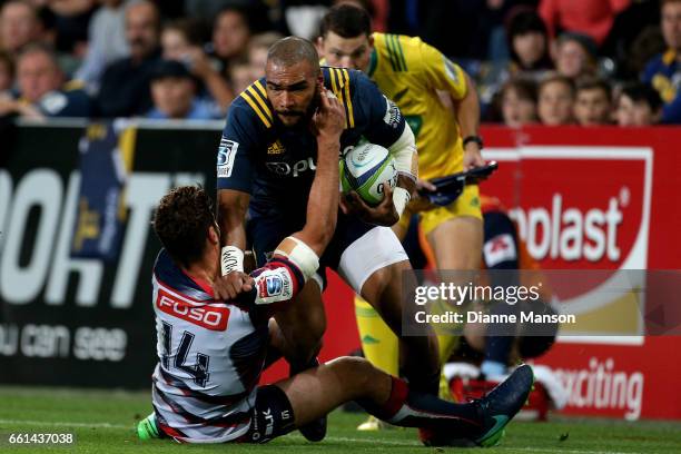 Patrick Osborne of the Highlanders tries to break a tackle during the round six Super Rugby match between the Highlanders and the Rebels at Forsyth...