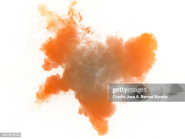 explosion of a cloud of powder of particles of  colors brown and orange on a white background - etéreo stockfoto's en -beelden