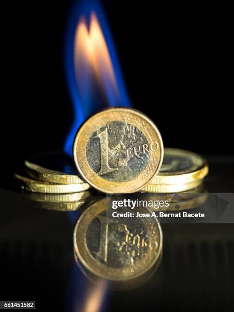 euro coin burned by the fire of the crisis of brexit - negocio stock pictures, royalty-free photos & images