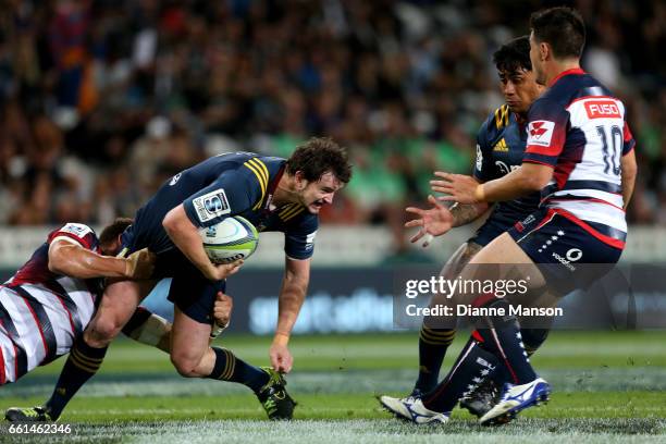 Richard Buckman of the Highlanders looks to off load the ball to Malakai Fekitoa during the round six Super Rugby match between the Highlanders and...