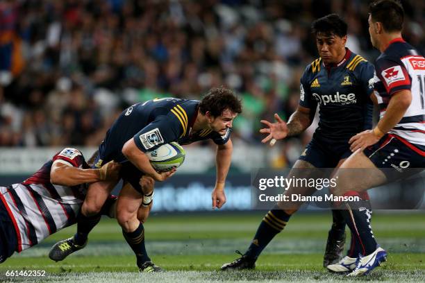 Richard Buckman of the Highlanders looks to off load the ball to Malakai Fekitoa during the round six Super Rugby match between the Highlanders and...