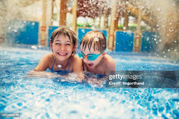 broer en zus spelen in resort zwembad. - pool boat stockfoto's en -beelden