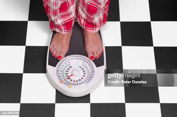 15 stone overweight woman on bathroom scales - balancing scale stock pictures, royalty-free photos & images