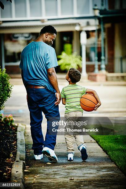 father and son on the way to play basketball - boys sport pants stock pictures, royalty-free photos & images