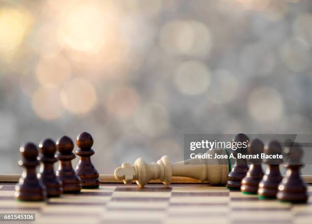 chessboard on a table (checkmate), illuminated by the light of the sun outdoors - check mate stock pictures, royalty-free photos & images