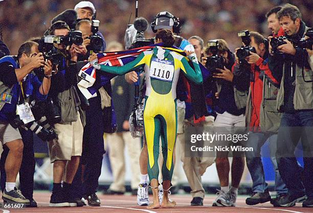 Cathy Freeman of Australia is swamped by photographers after winning gold in the Womens 400m Final at the Olympic Stadium September 25, 2000 on Day...