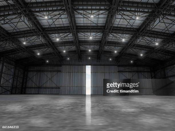 empty warehouse by day wit one door open - wholesale stockfoto's en -beelden