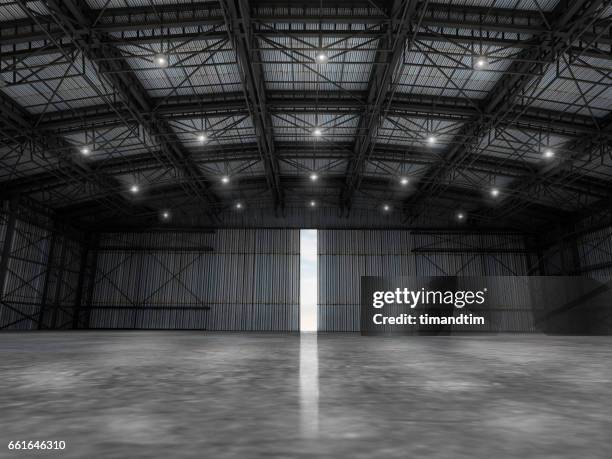 empty warehouse by day wit one door open - airplane hangar stock pictures, royalty-free photos & images