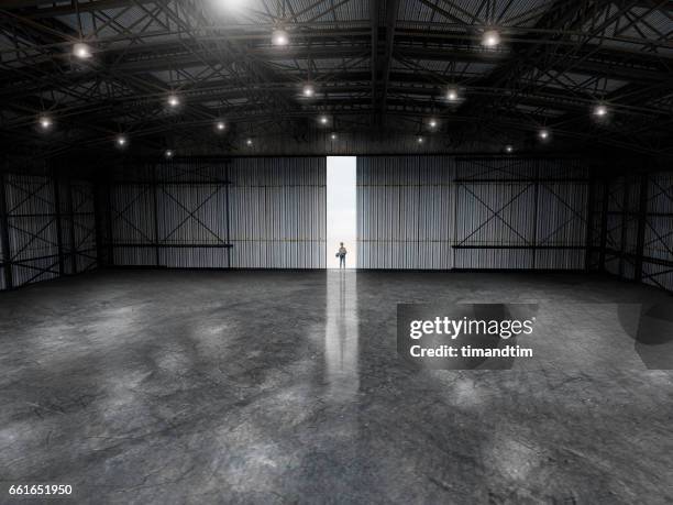 woman with a blueprint in an empty warehouse by day - door hanger stock pictures, royalty-free photos & images