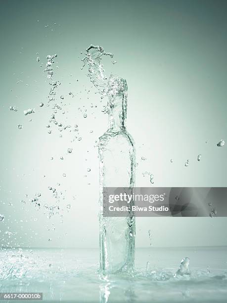 water splashing from bottle - bottle water stock-fotos und bilder