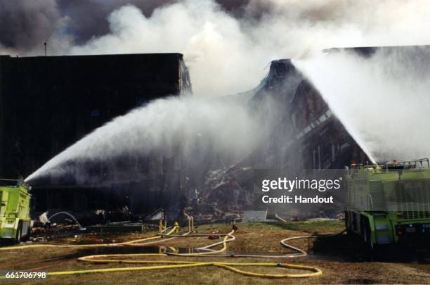In this handout provided by the Federal Bureau of Investigation , first responders pour water on the fire on scene following an attack at the...