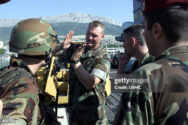 First Lieutenant Mike E. Ogden, center, Battalion Landing Team 2/2 Golf Company's 3rd Platoon Commander, talks to Croatian soldiers September 25,...