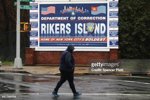 Woman walks by a sign at the entrance to Rikers Island on March 31, 2017 in New York City. New York Mayor Bill de Blasio has said that he agrees with...
