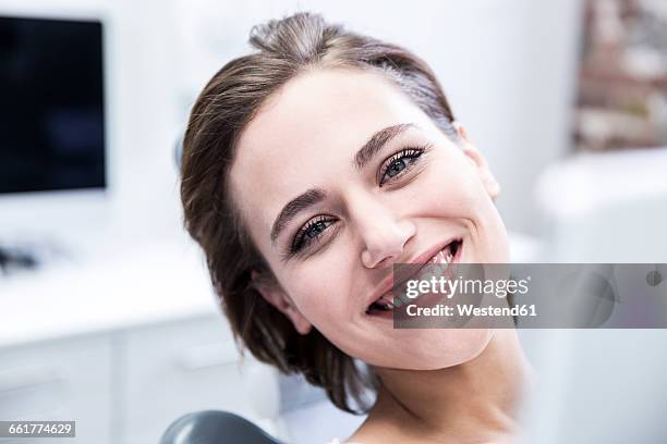 young woman at the dentist receiving treatment - dentista foto e immagini stock