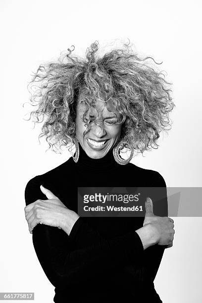 portrait of laughing woman with afro wearing black turtleneck pullover - black and white portrait woman stockfoto's en -beelden