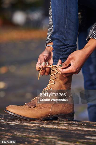 hands of woman tying boot - leather boots stock pictures, royalty-free photos & images