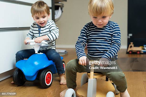 two little boys playing at home with toy cars - bobbycar stock pictures, royalty-free photos & images