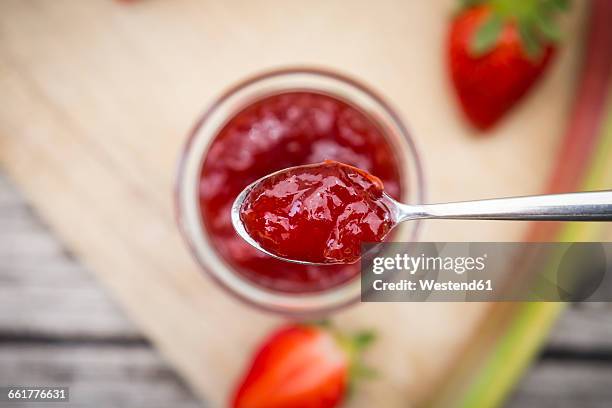 glass of homemade strawberry rhubarb jam - marmelade stock-fotos und bilder