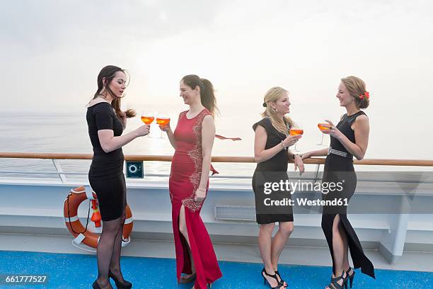 four women with aperitives standing on deck of a cruise liner - cruise liner foto e immagini stock