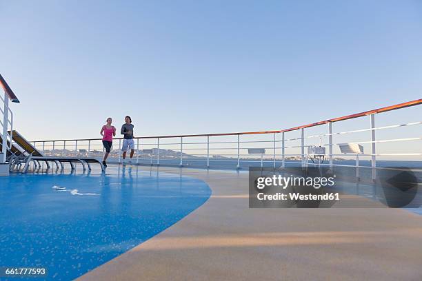 young couple is jogging around the shipdeck of a cruise ship, mediterranean sea - passenger train stockfoto's en -beelden
