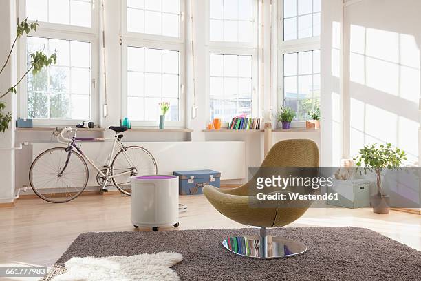 home interior with bicycle and chair - armchair stock pictures, royalty-free photos & images