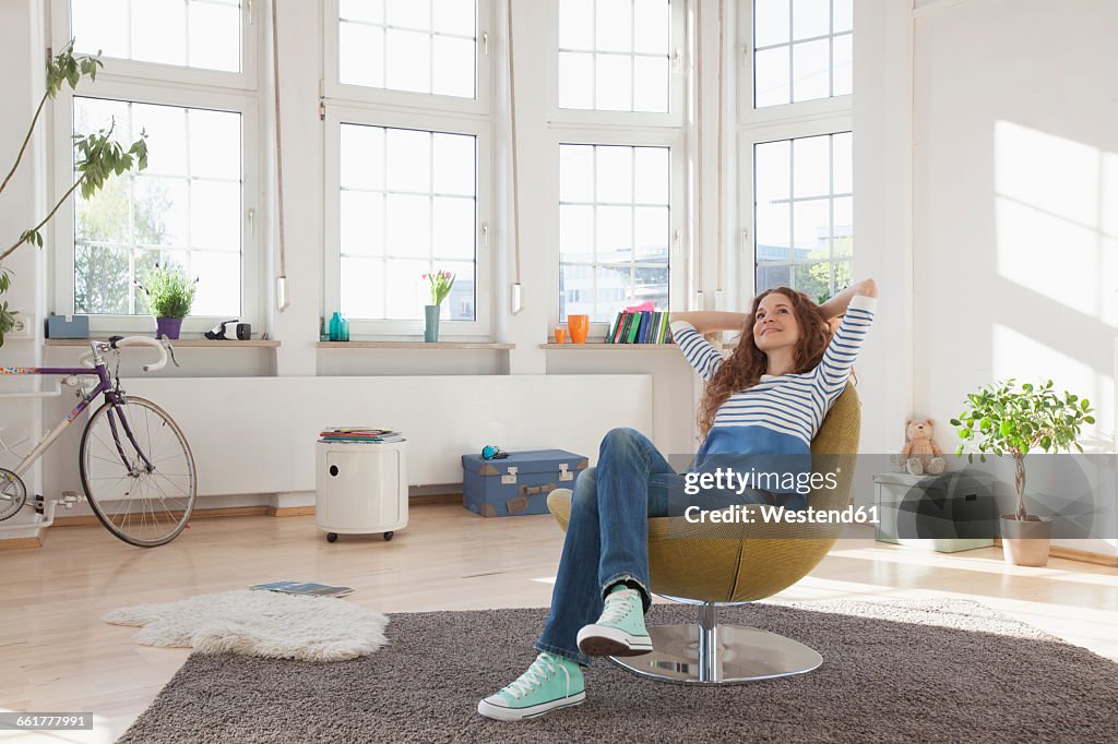 Relaxed woman at home sitting in chair