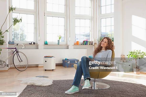 relaxed woman at home sitting in chair - armchair imagens e fotografias de stock