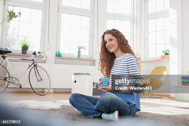 smiling woman at home sitting on floor - coffee bike stock pictures, royalty-free photos & images