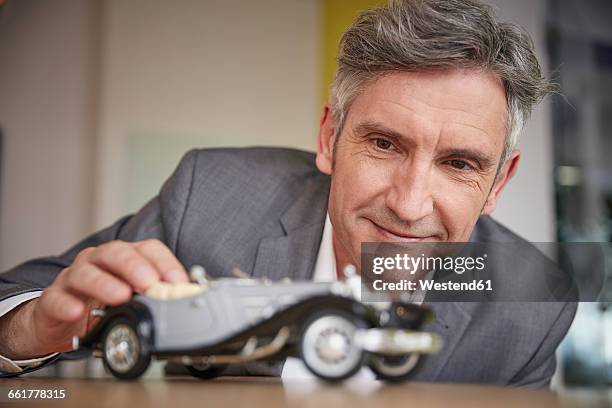 mature man playing with classic car model - status symbol stock pictures, royalty-free photos & images