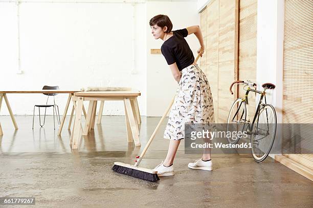 woman sweeping in a studio - woman sweeping stock pictures, royalty-free photos & images