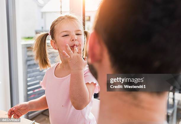 girl with finger in mouth looking at father - finger in mouth stock pictures, royalty-free photos & images