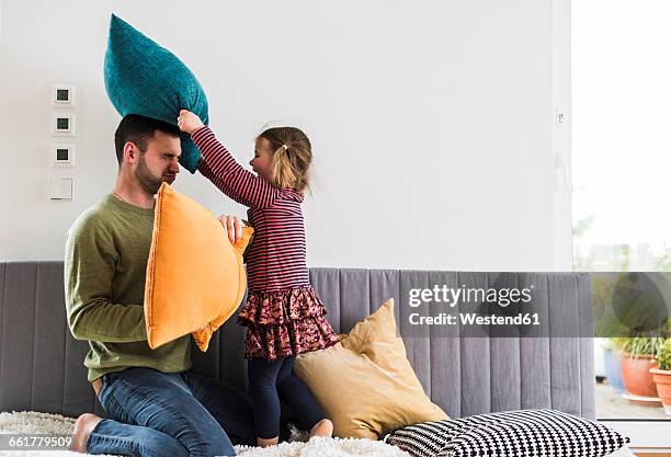 father and daughter having a pillow fight - luta de almofada imagens e fotografias de stock