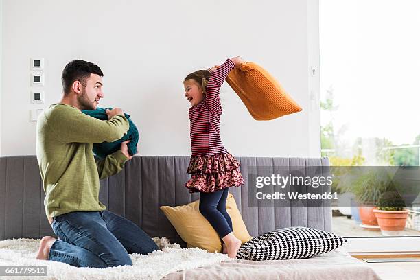 father and daughter having a pillow fight - pillow fight stock pictures, royalty-free photos & images