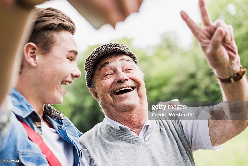 Grandfather and grandson taking selfie with smartphone