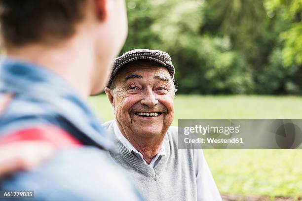 portrait of senior man talking with his grandson - face à face photos et images de collection