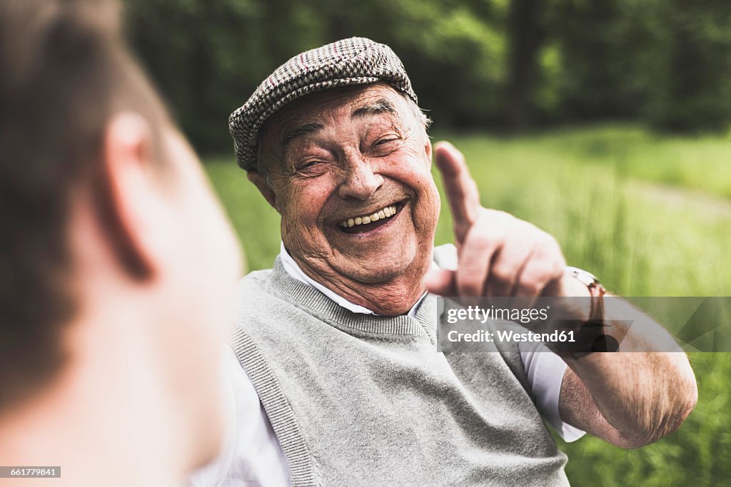 Portrait of laughing senior man talking to his grandson